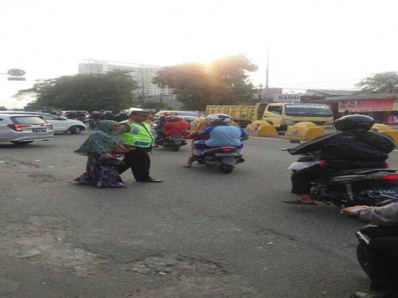 IMG-kanit-lantas-polsek-jatiuwung-berikan-pelayanan-kepada-warga-yang-ingin-menyebrang-jalan